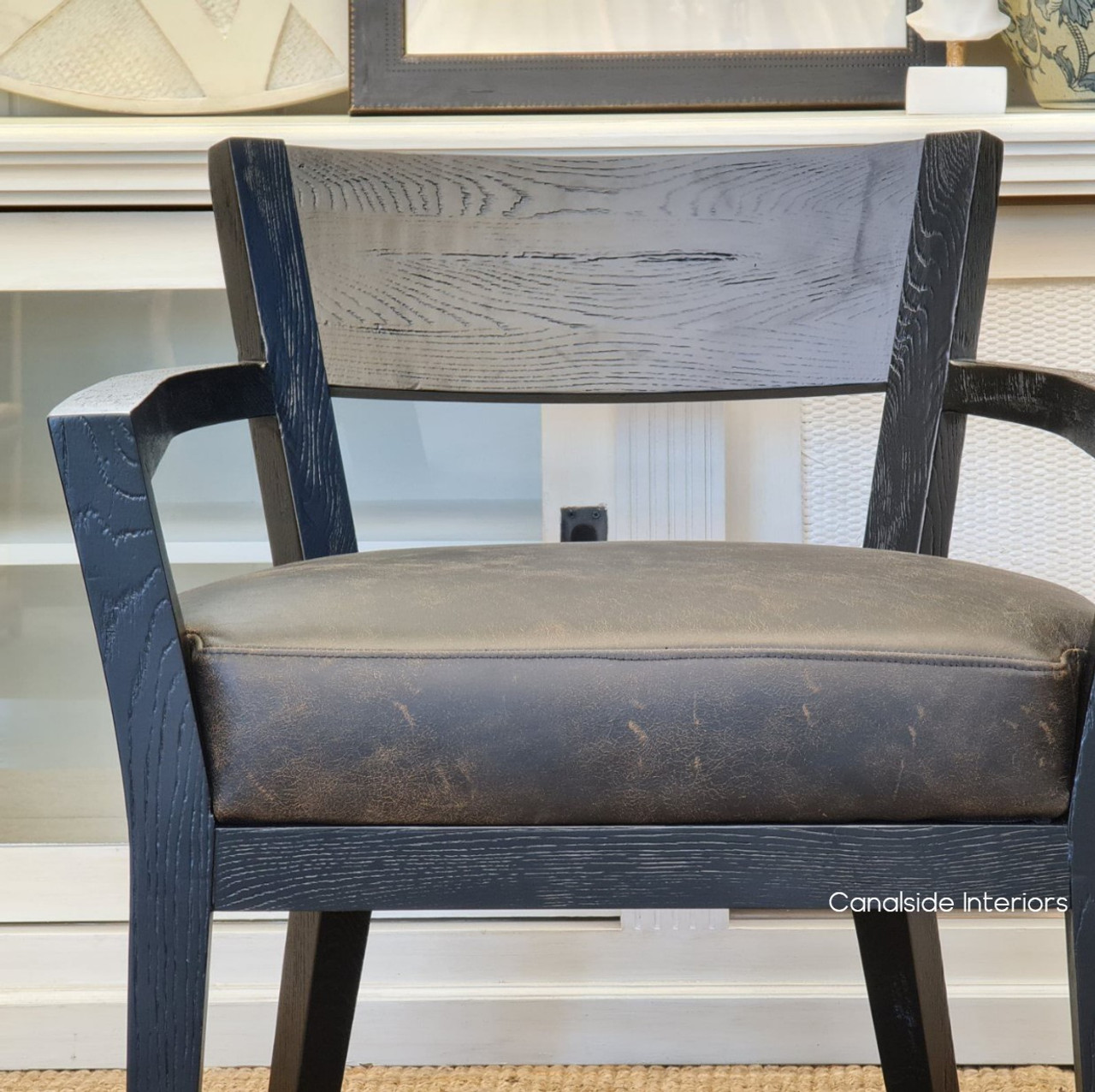 Close-up of the armchair's leather detailing, emphasizing the rich texture and color that embodies classic American design with a modern twist.