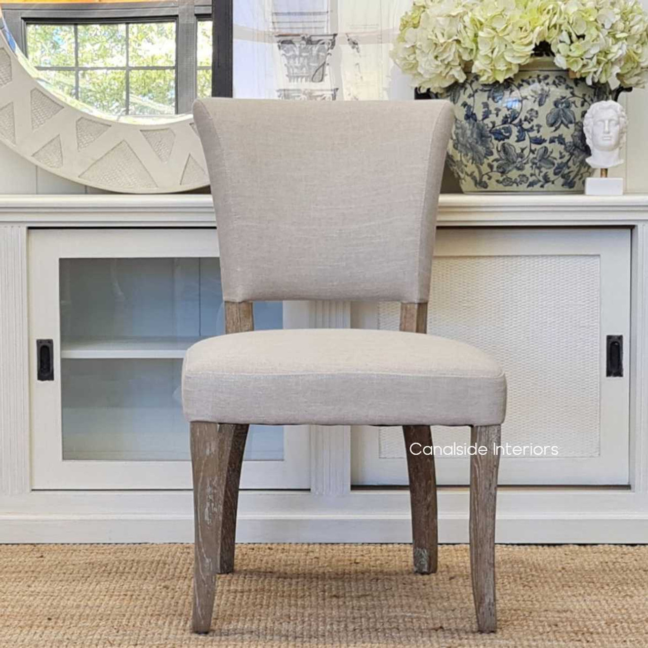 Front view of the Mimi Dining Chair in cream with weathered oak legs, displaying its sophisticated sensibility and classic Hamptons style.