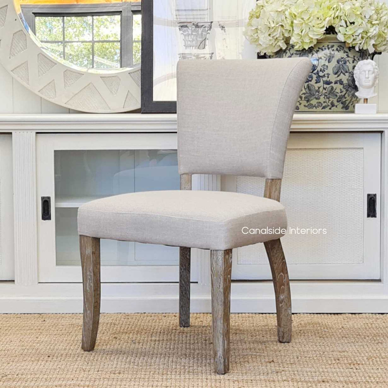 The Mimi Dining Chair in a sunlit dining room, capturing the airy and elegant vibe perfect for coastal-inspired interiors.