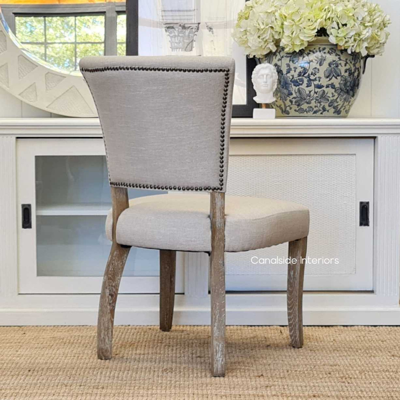 Zoomed-in view of the weathered oak legs of the Mimi Dining Chair, showcasing the natural beauty and texture of the wood.