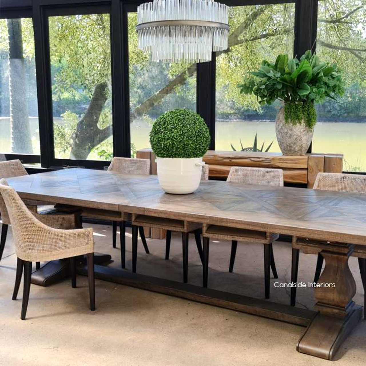 Profile view against a Hamptons backdrop, highlighting the table's sleek silhouette and timeless appeal.