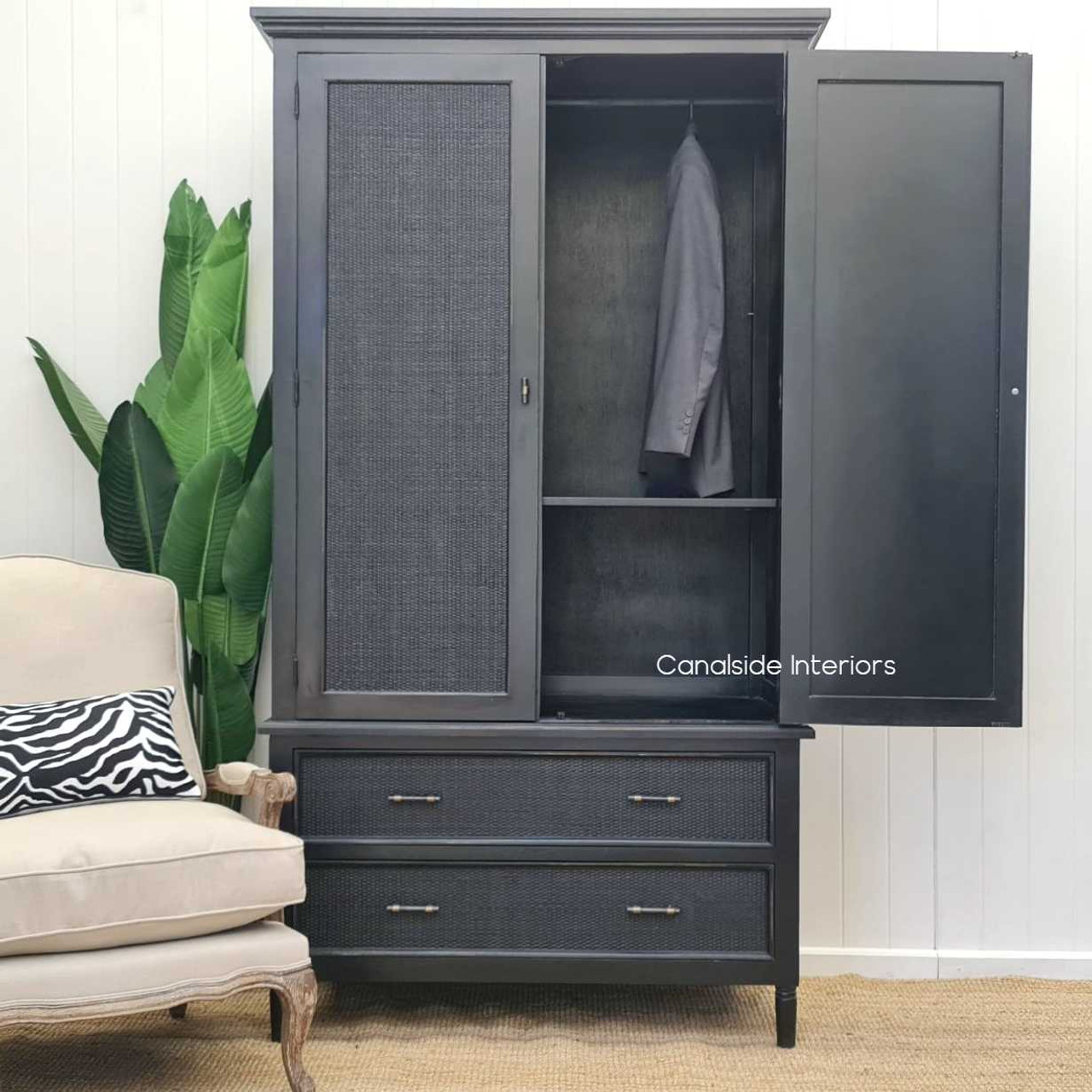 Captured in a well-lit room, the wardrobe's distressed charcoal/black finish complements any home style with its reflective quality and timeless design.