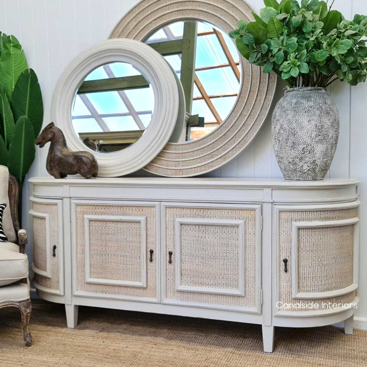 A lounge room centerpiece, the Francia Rattan Sideboard from Canalside Interiors features a distressed stone hue, embodying chic storage solutions with a classic twist.