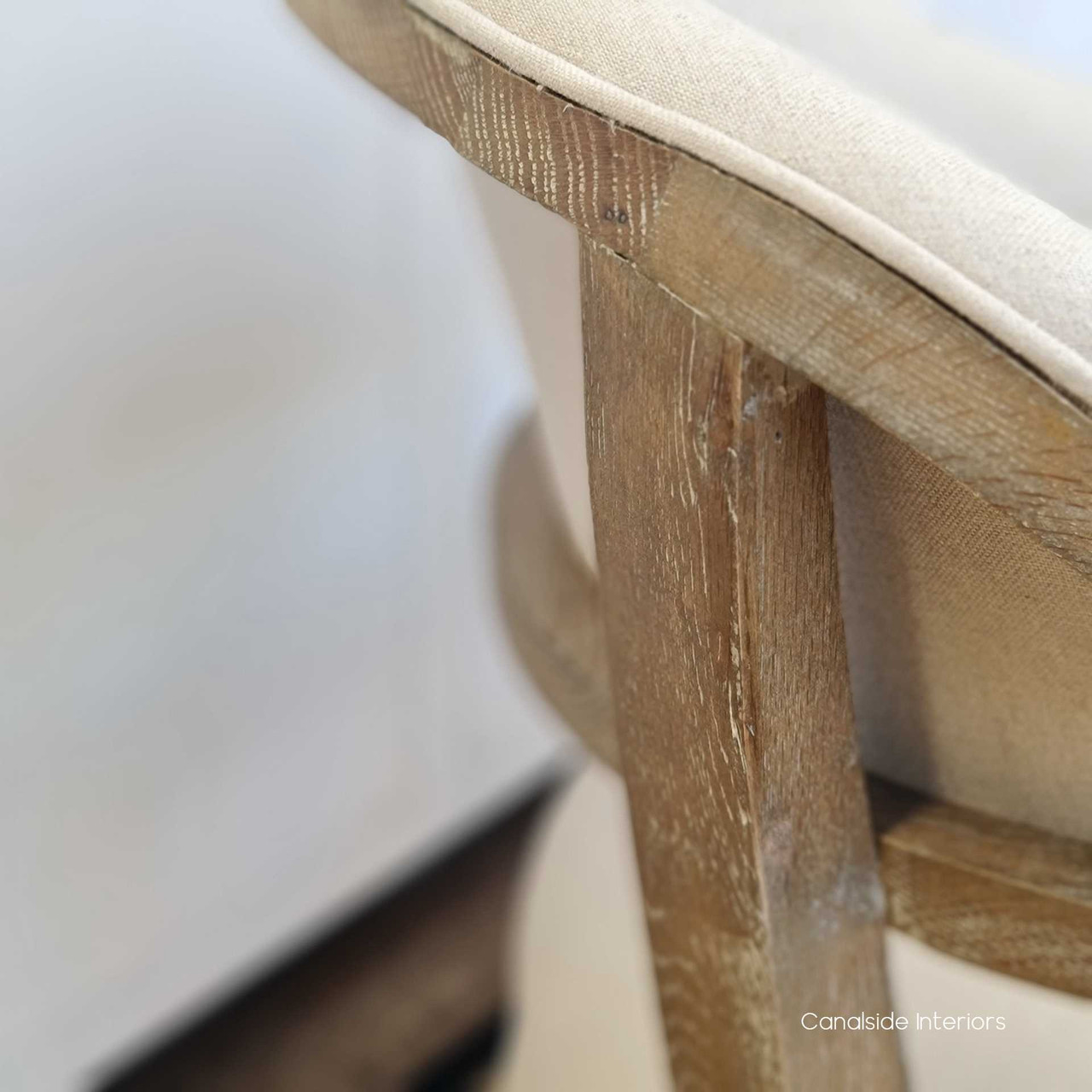 Close-up on the chair's linen blend fabric, emphasizing the texture and quality that add comfort and elegance to the modern design.