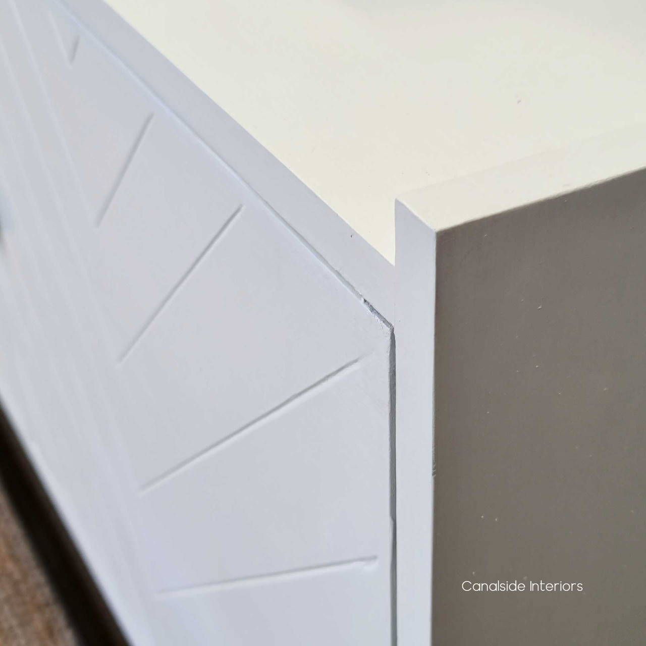 The distressed white finish and understated herringbone pattern of this TV sideboard capture the essence of modern plantation style - Canalside Interiors.