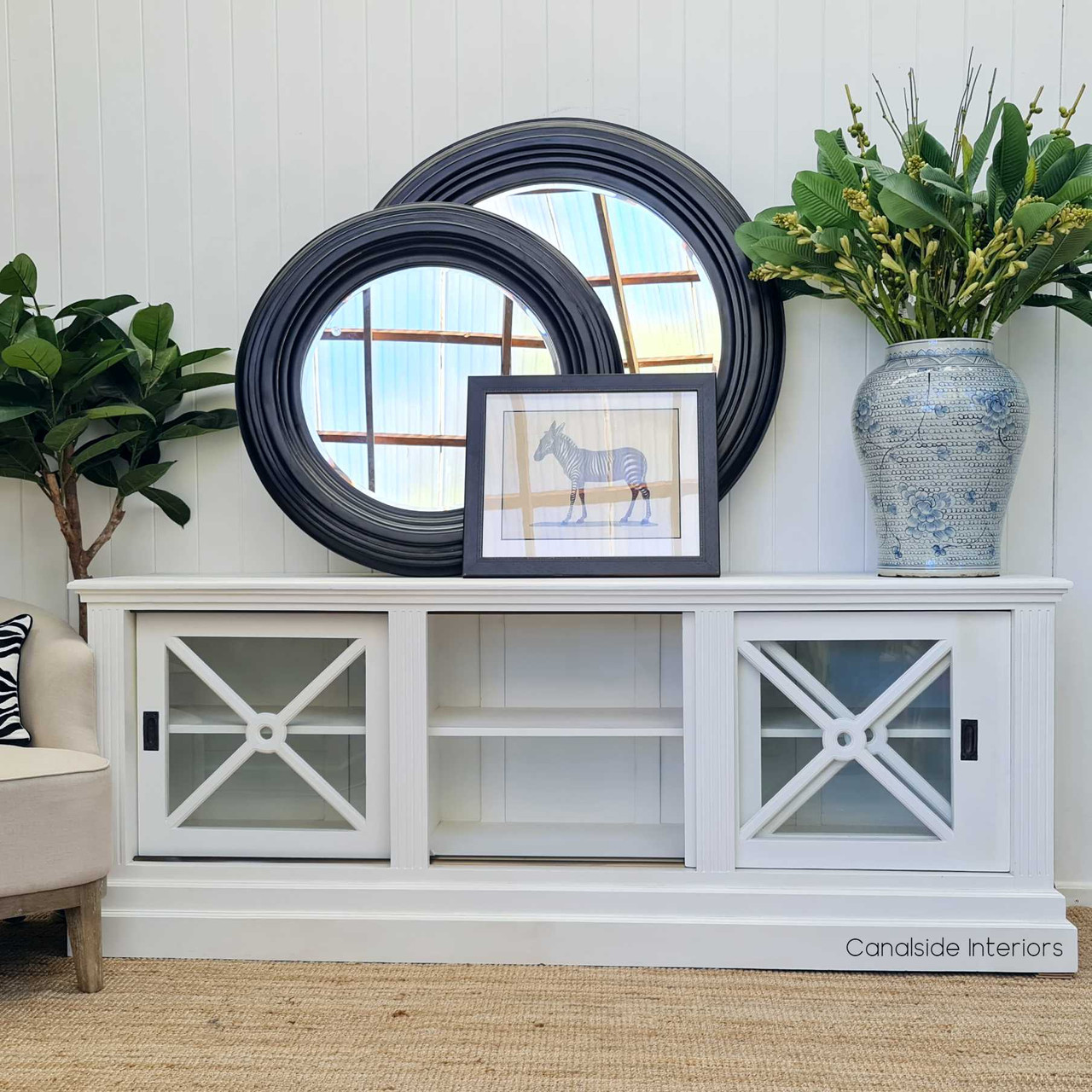 View of the sideboard with the glass doors slightly open, revealing the ample storage space inside.