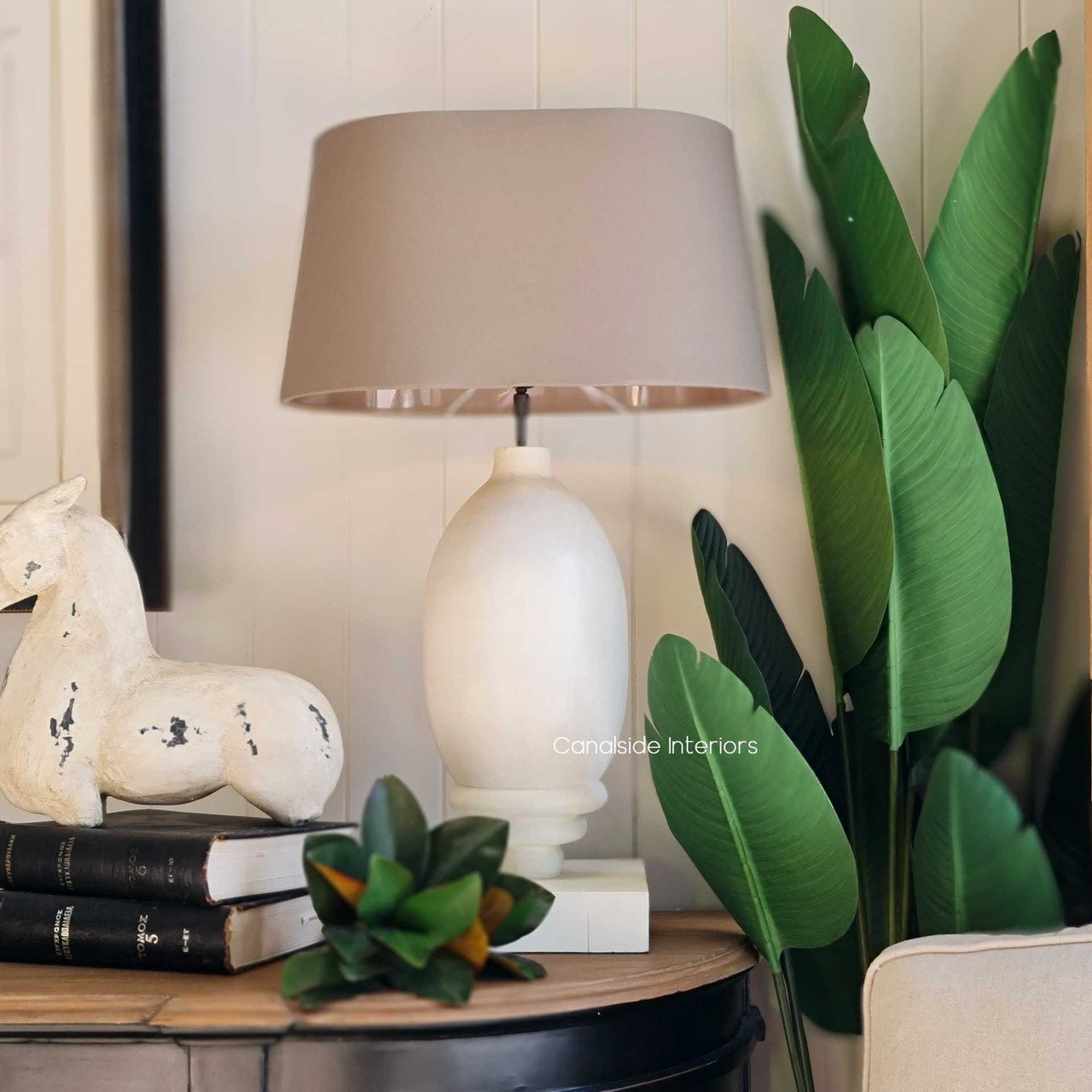 Elevate your dining room or library with the timeless Clemence Lamp from Canalside Interiors, featuring a modern white base paired with a classic silhouette. The quality construction and coastal-inspired design reflect a Hamptons lifestyle