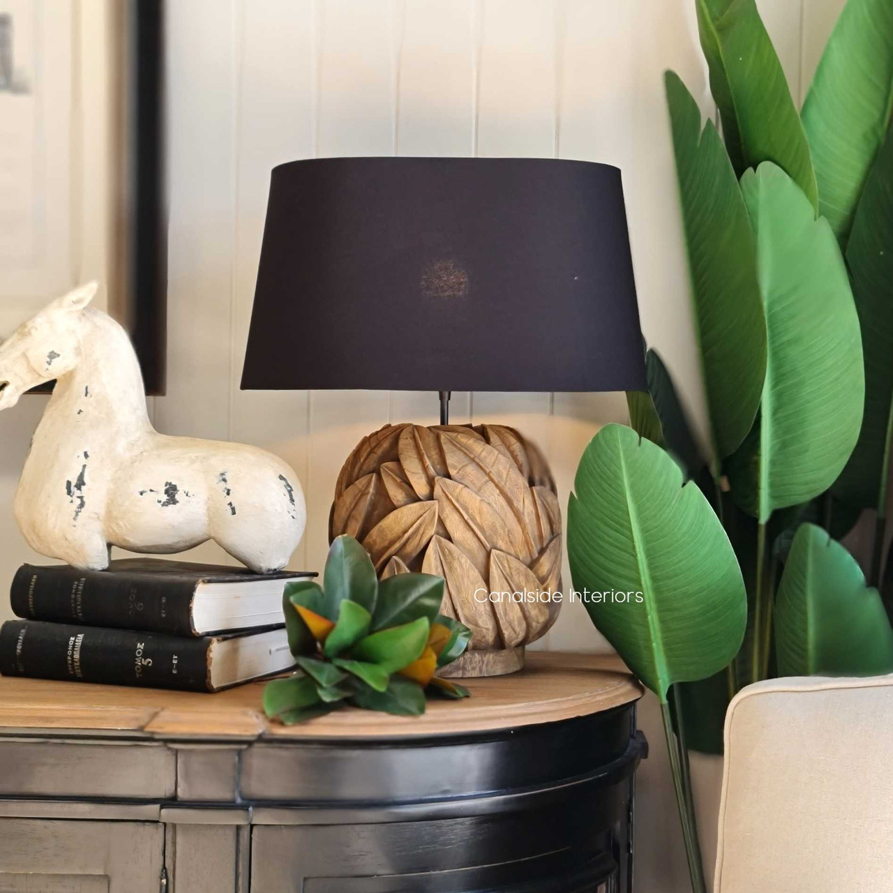 The Botanique Lamp illuminating a cozy reading nook, demonstrating its functionality as both a statement piece and a source of ambient light.