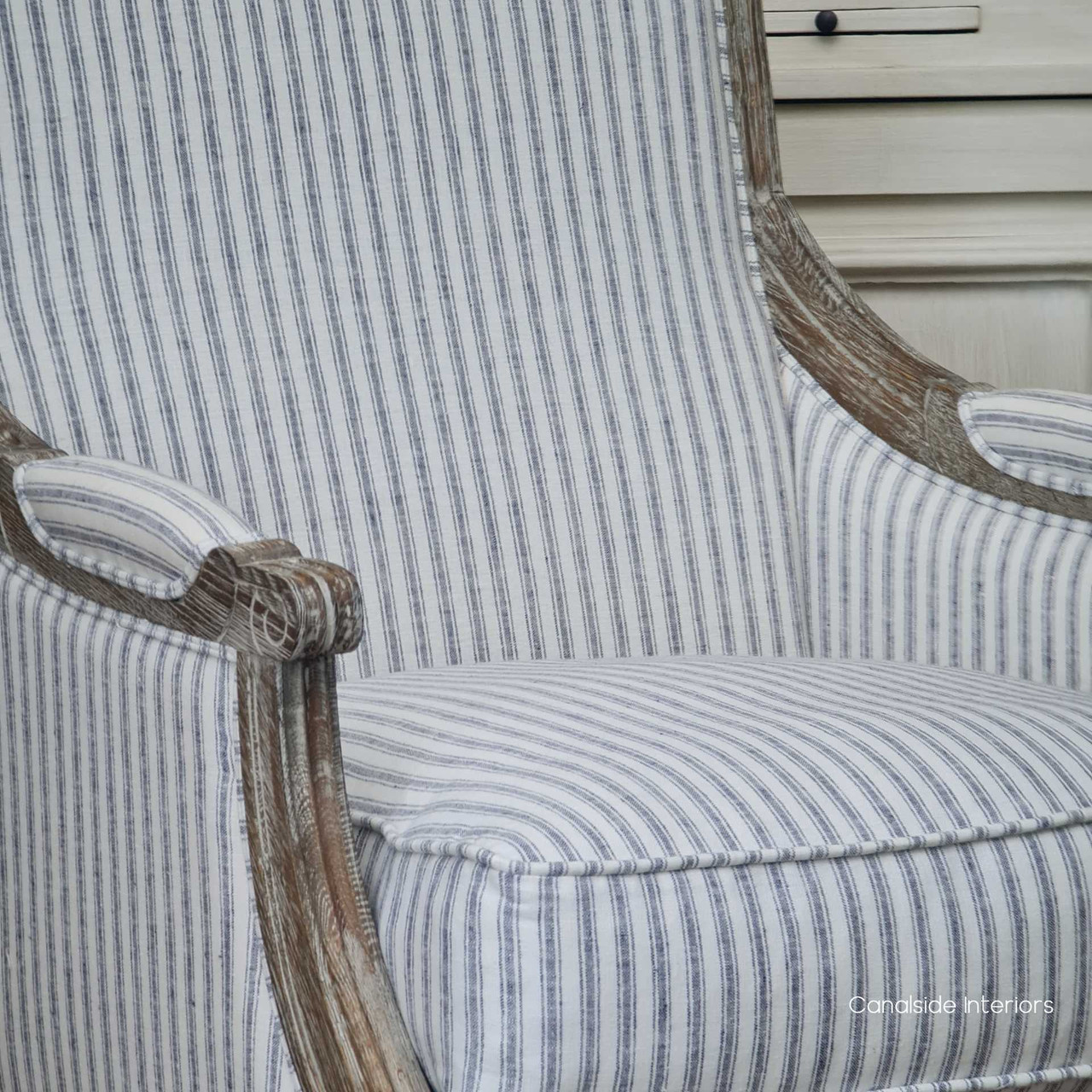 Detail of the armchair's striped upholstery, emphasizing the quality and sophistication of the linen blend fabric.