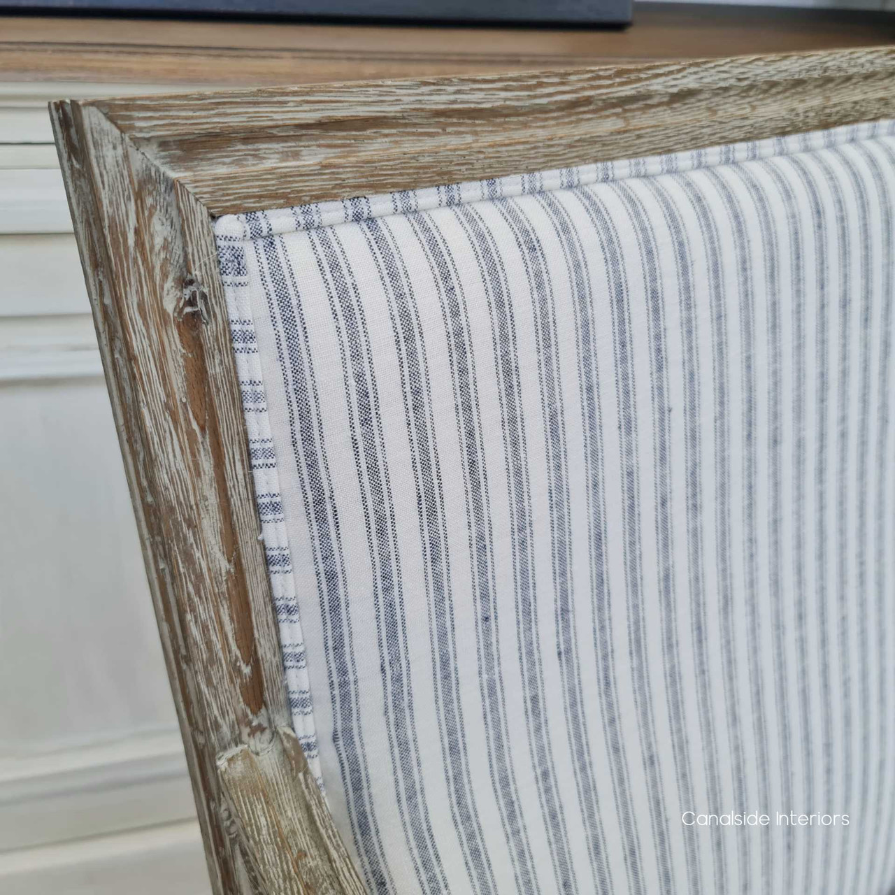 Close-up of the weathered oak frame, highlighting the armchair's hand-crafted carvings and attention to detail.