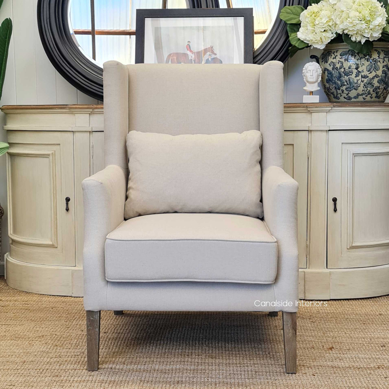 Profile view against a minimalist backdrop, highlighting the Wingback Armchair's timeless design and chic aesthetic.