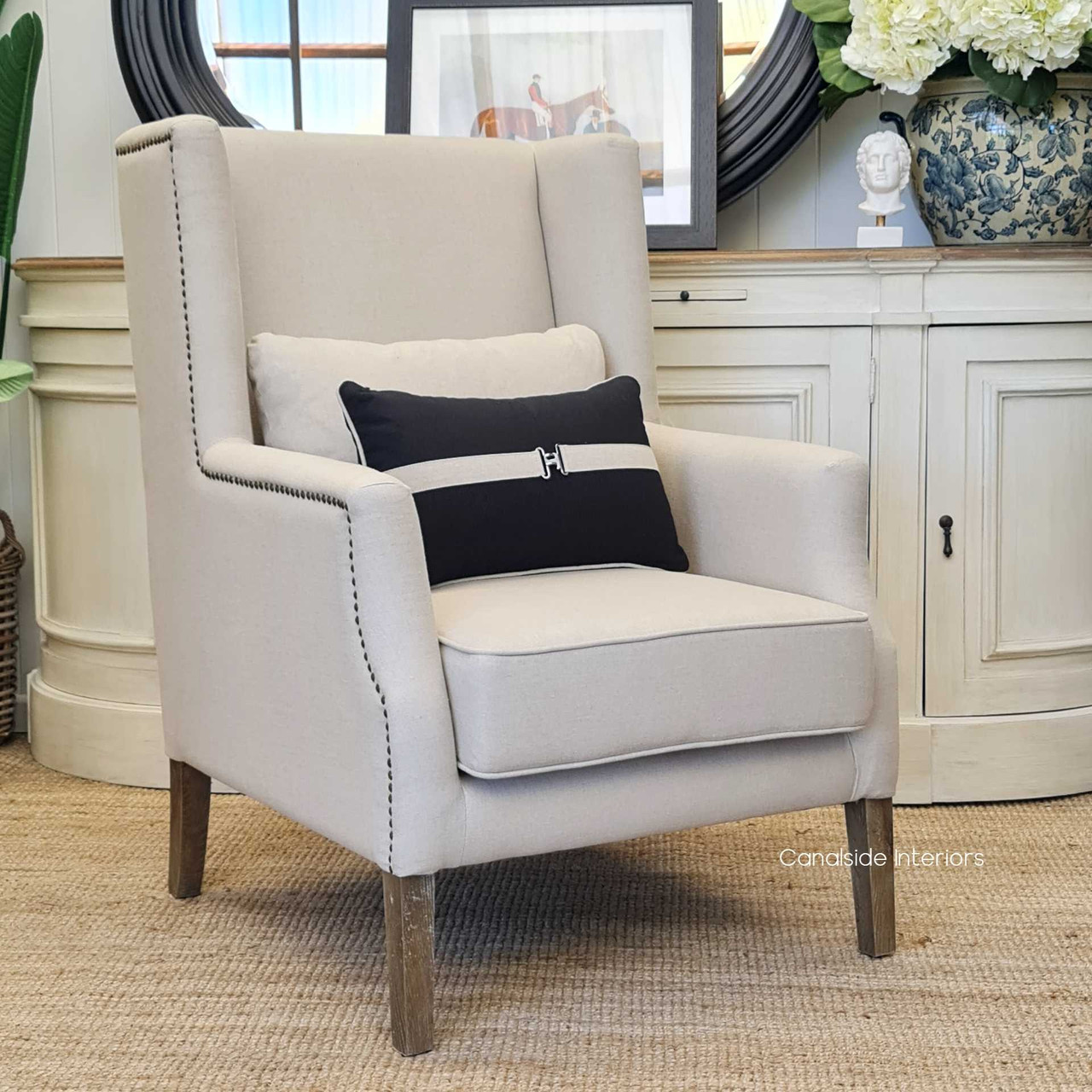 Side view focusing on the chair's unique blue striped upholstery and brass studs, adding a touch of sophistication to any room.