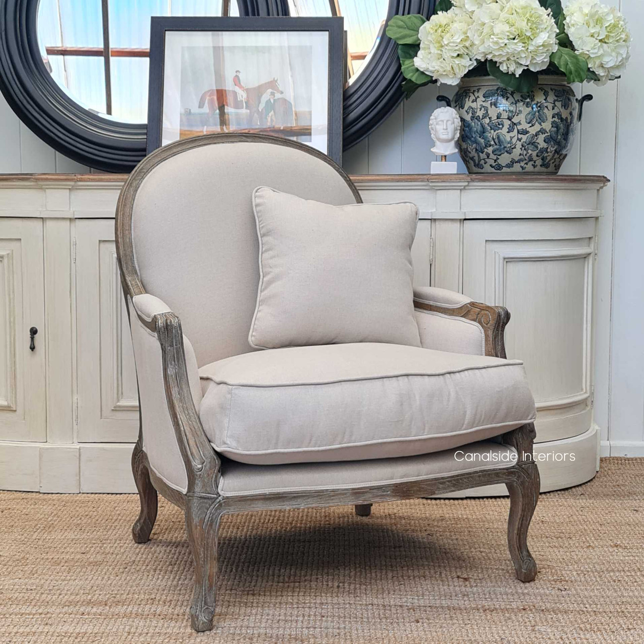 The armchair in a library setting, highlighting its suitability as a comfortable reading chair, surrounded by books and warm lighting.