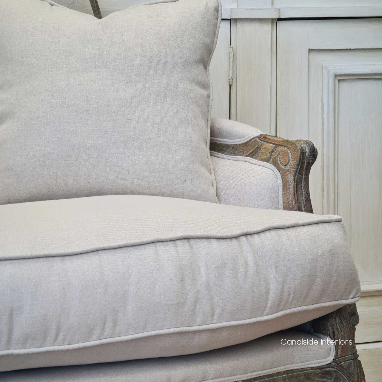 Zoomed-in texture shot of the cream linen blend upholstery, offering a tactile sense of the armchair's comfort and luxury.