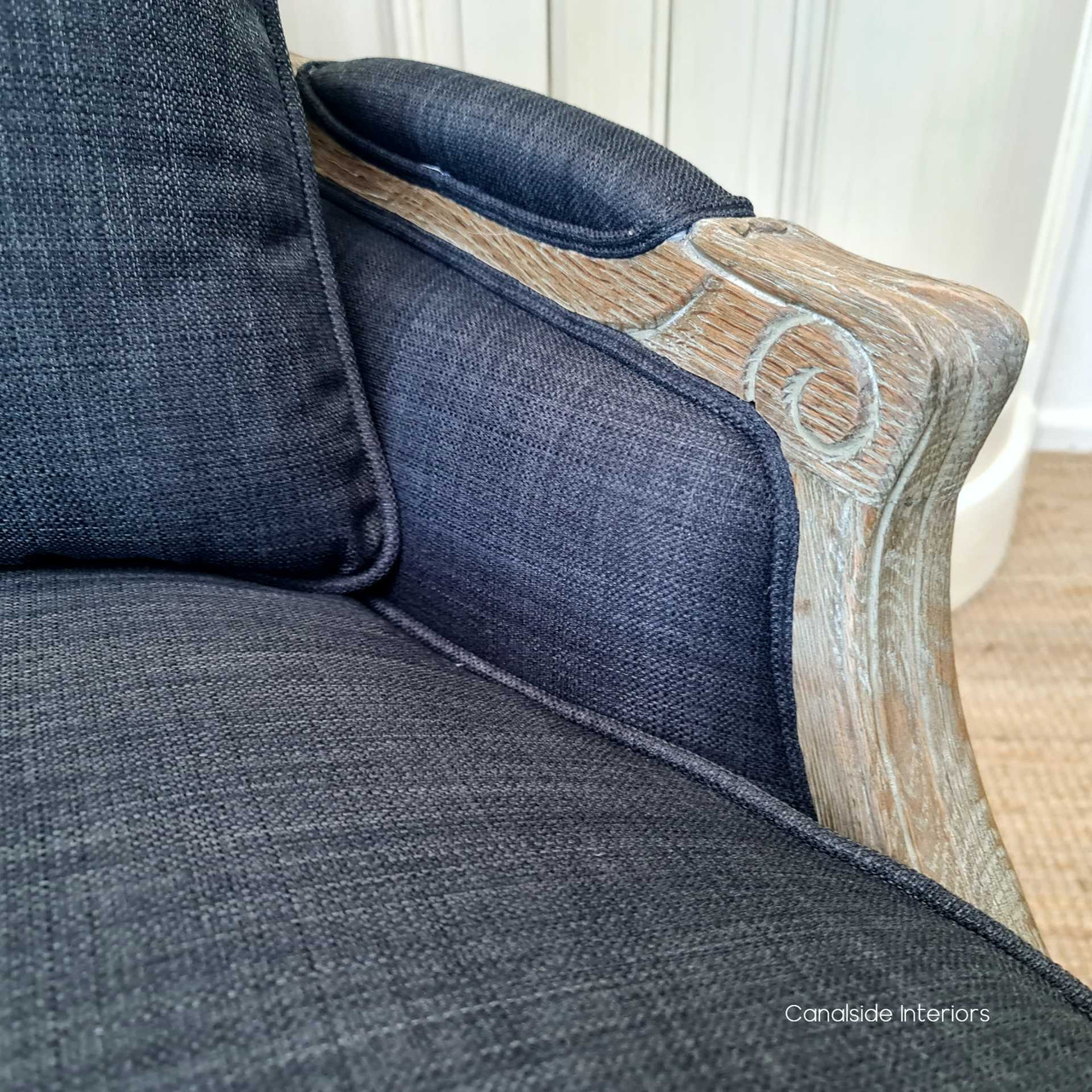 Close-up of the armchair's weathered oak frame, highlighting the craftsmanship and French Provincial design, ideal for adding classical elegance to any interior.