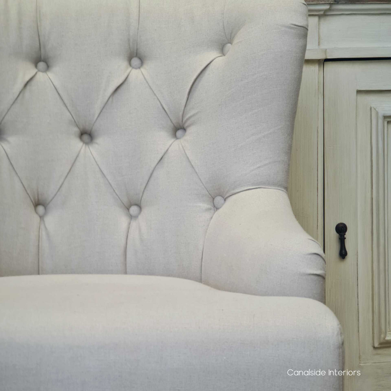 The inviting form of the Ascott Buttoned Armchair, positioned to add charm and sophistication to a cozy reading nook.