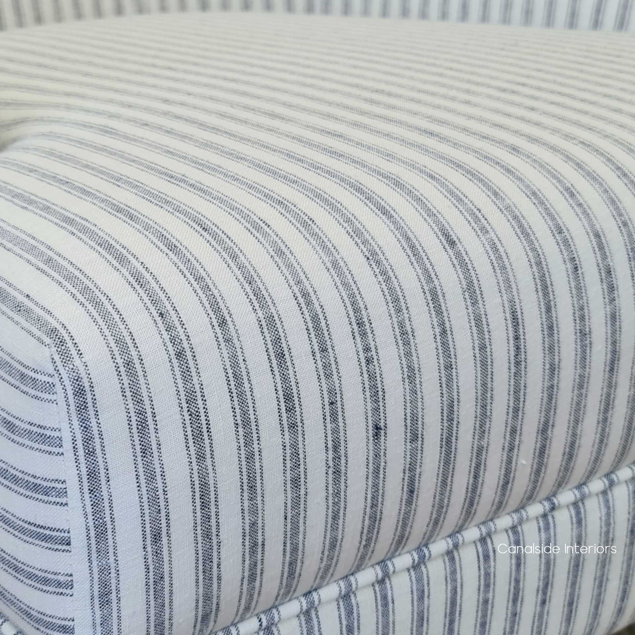 Close-up of the blue-striped linen upholstery on the Ascott Buttoned Armchair, perfect for a Hamptons-themed bedroom.