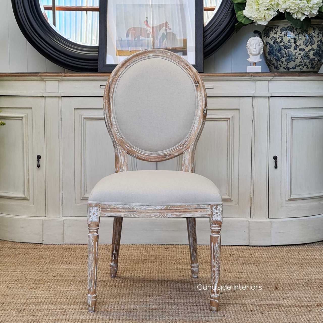 French-inspired Sansa Chair with elegant oval back, providing a timeless accent in a coastal-themed bedroom