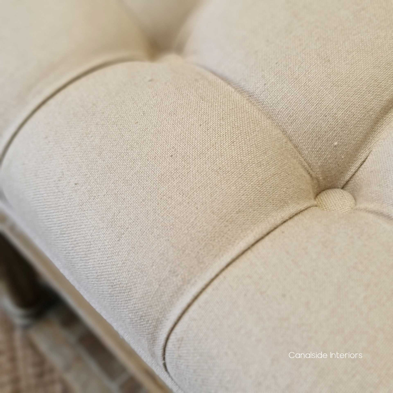 Detail shot of the intricate button tufting, showcasing the craftsmanship and attention to detail in the ottoman's design.