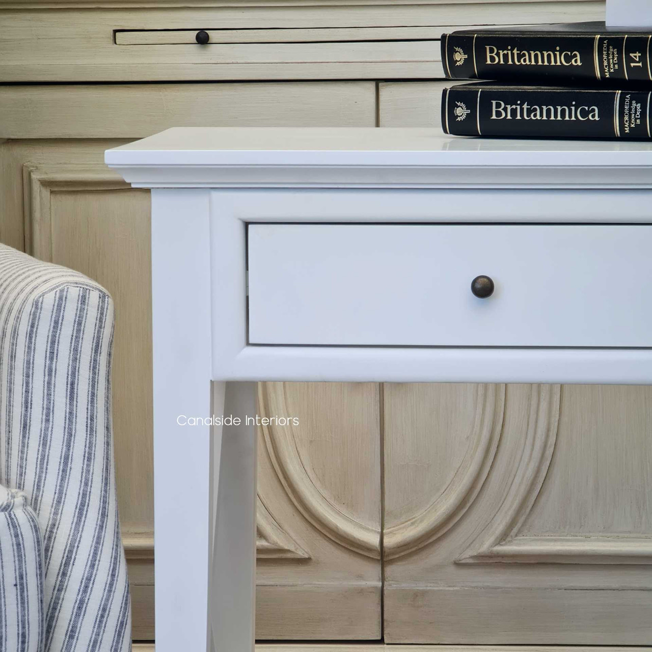 The singular drawer of the Hampton Avenue Bedside/Side Table offers convenient storage for a timeless bedroom