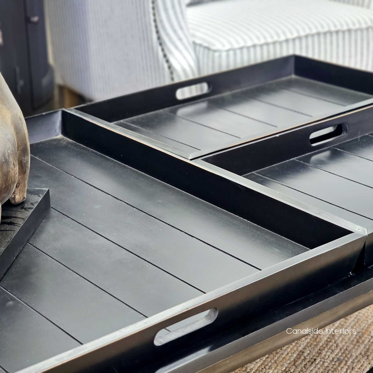Close-up on one of the three removable butler trays, highlighting the table's functionality and elegant design.