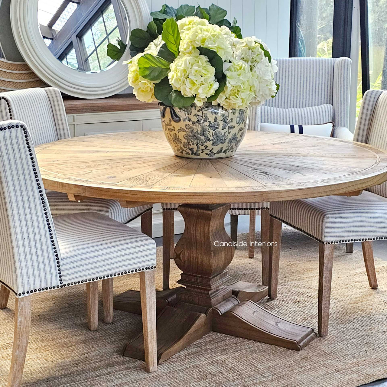 This Danbury Round Oak Dining Table, resplendent in its natural wood finish, stands ready to host intimate dinners or become the centerpiece in a stylish lounge room - Canalside Interiors Sydney