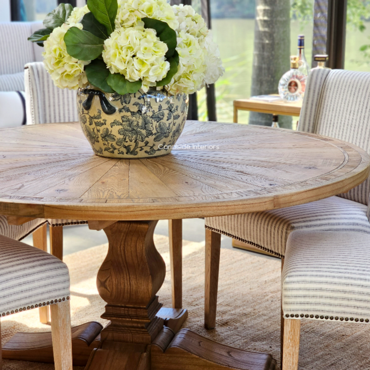Meticulously handcrafted, the Danbury Oak Round Table anchors your dining space with its robust pedestal and rich oak textures, embodying coastal luxury