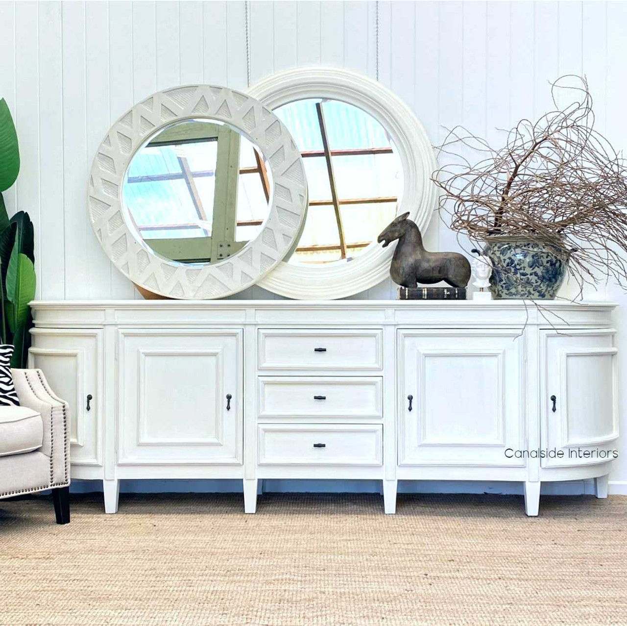 The Francia Grande Sideboard in distressed white commands attention in any living room, combining Canalside Interiors' craftsmanship with a Hamptons aesthetic