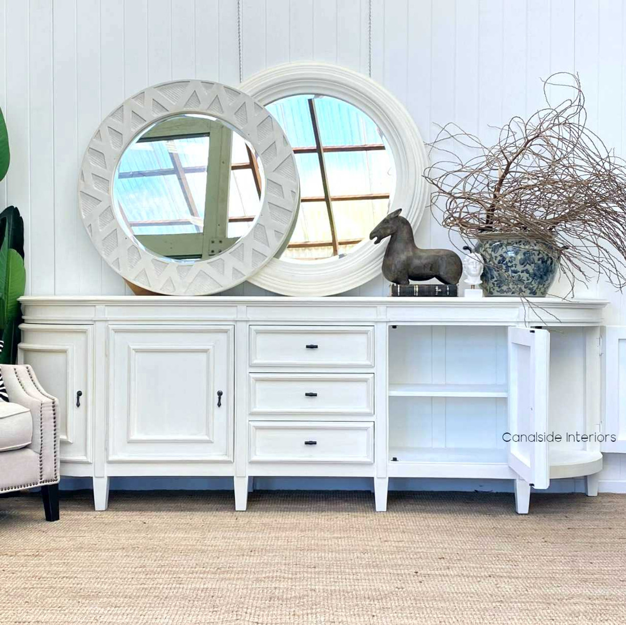 Adorn your bedroom with the Francia Grande Sideboard from Canalside Interiors; its distressed white hue and French curves adding a layer of coastal elegance.