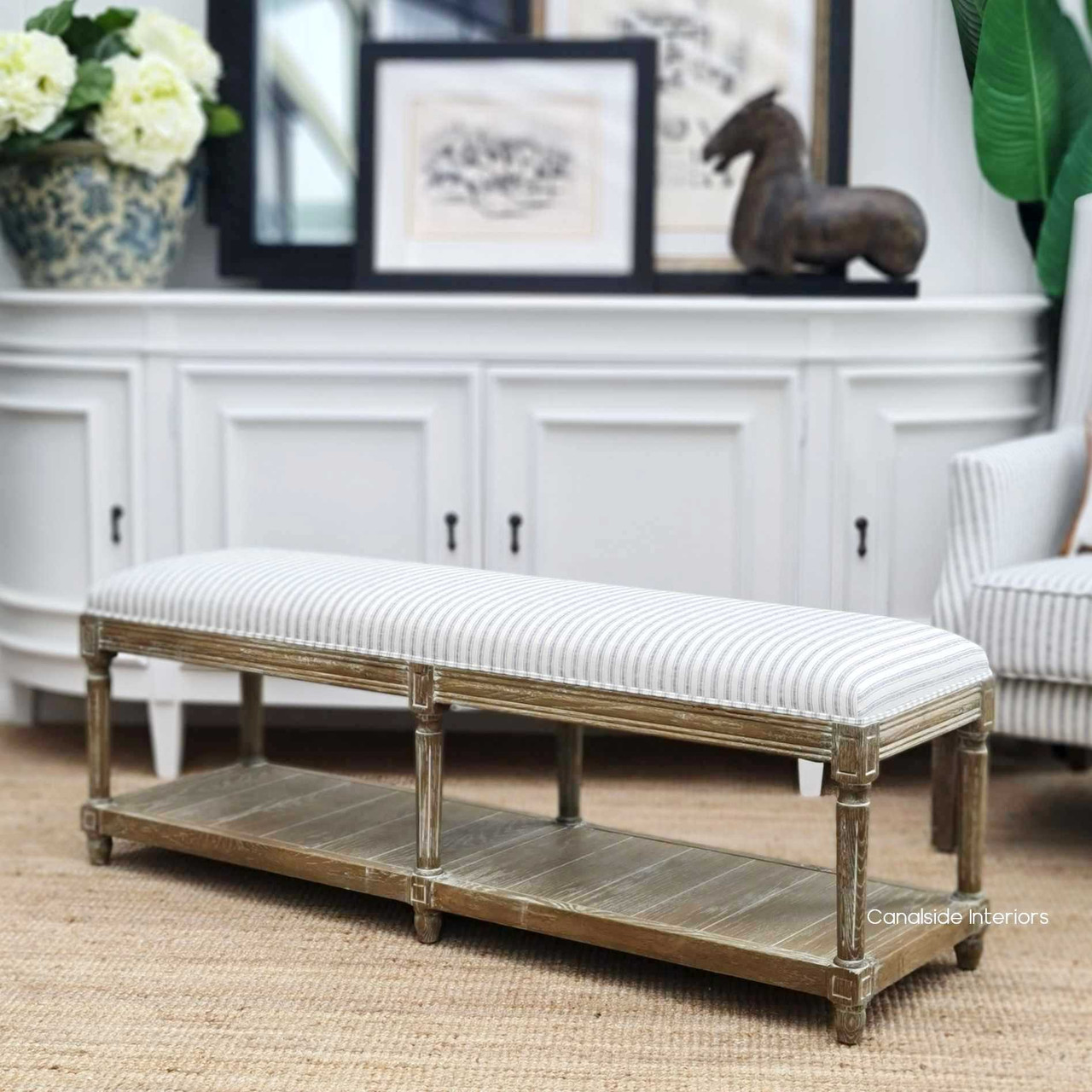 Elegant Providence Bed Ottoman with blue striped upholstery, nestled in a coastal-inspired bedroom, enhancing the serene ambiance.