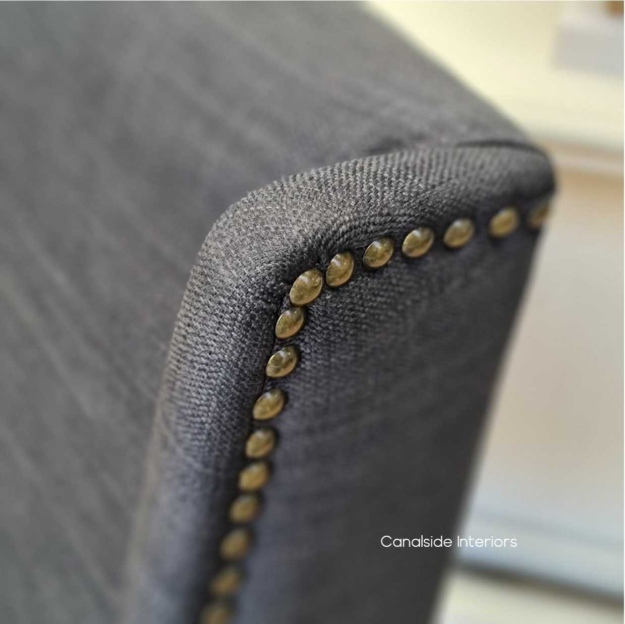 The Leclerc Chair exudes a coastal sophistication with its natural materials and detailed brass studs, ideal for serene interior design