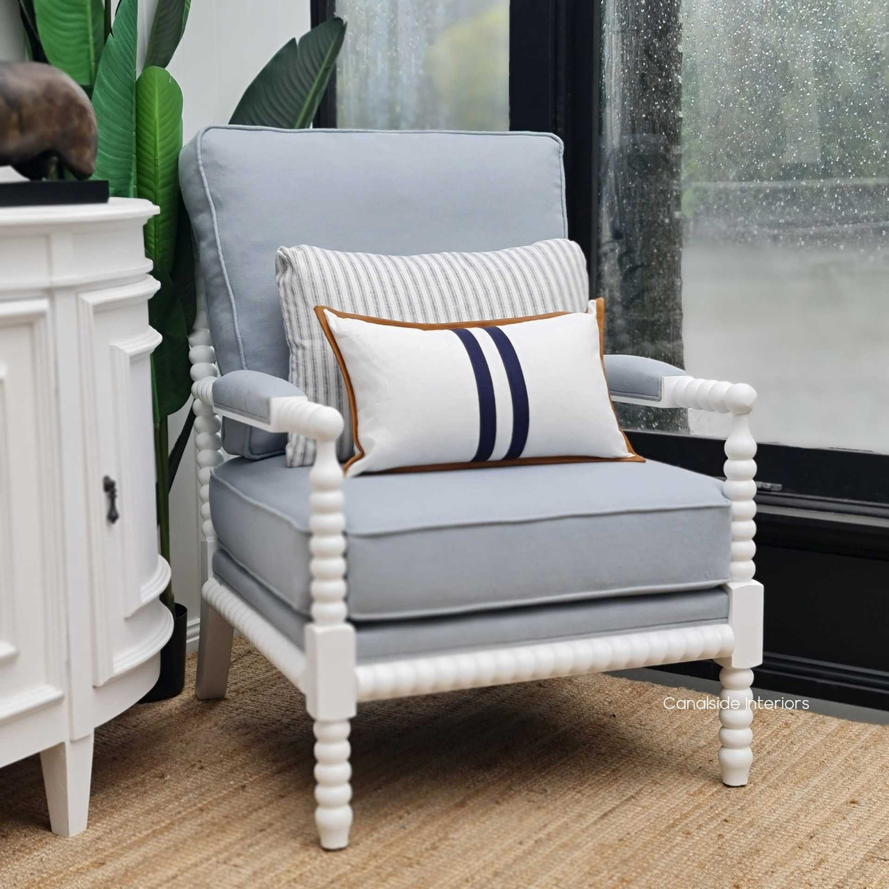Profile view against a minimalist backdrop, highlighting the armchair's elegant silhouette and timeless appeal.