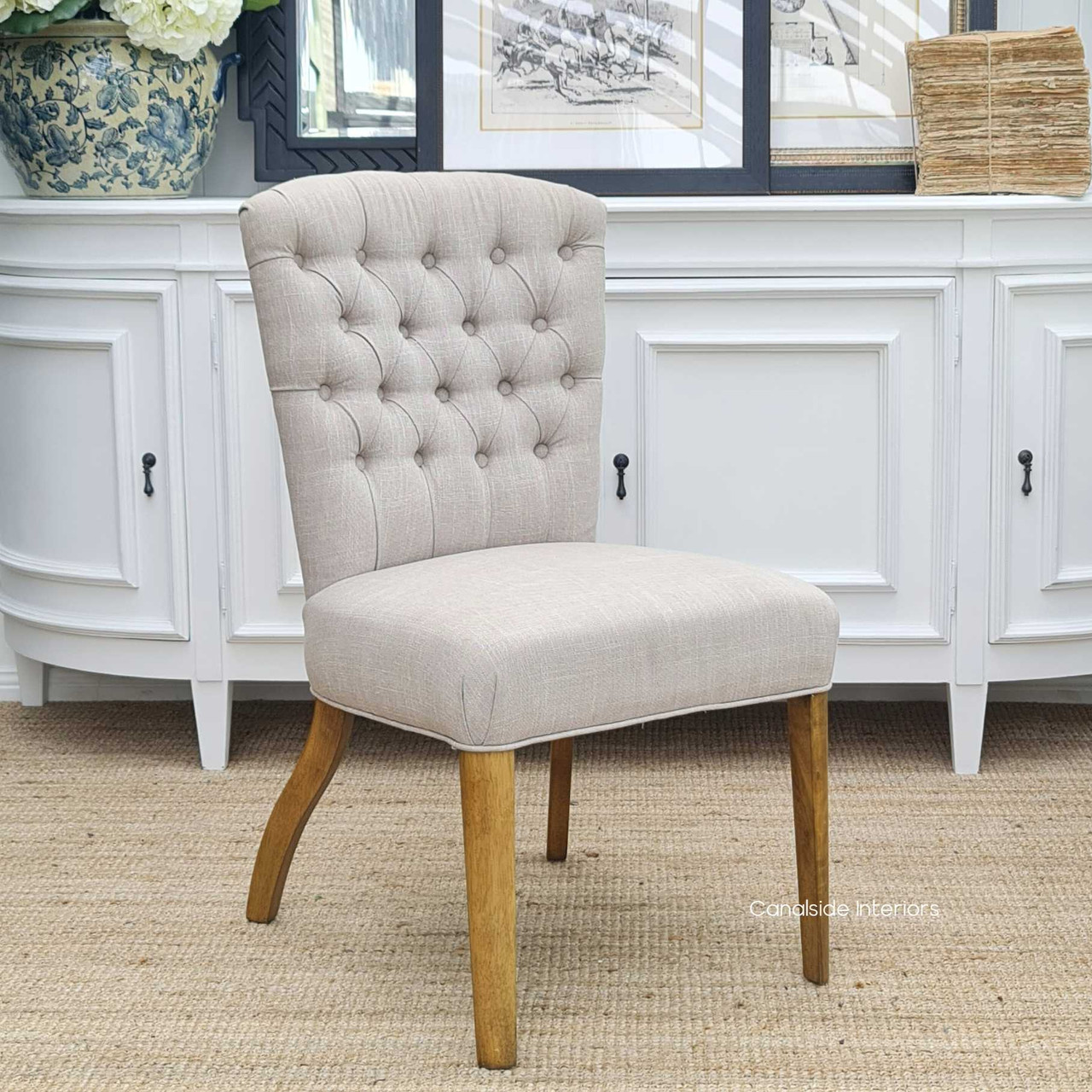 The Chelsea Buttoned Back Dining Chair in cream features a tufted design for a touch of Hamptons-style elegance in your dining room