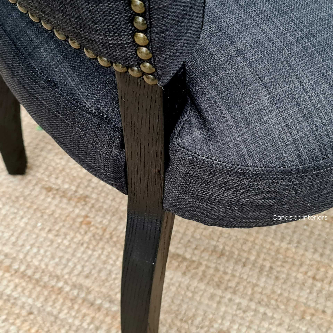 Angled view of the Mimi Chair's curved hardwood legs, merging classical beauty with modern dining room style