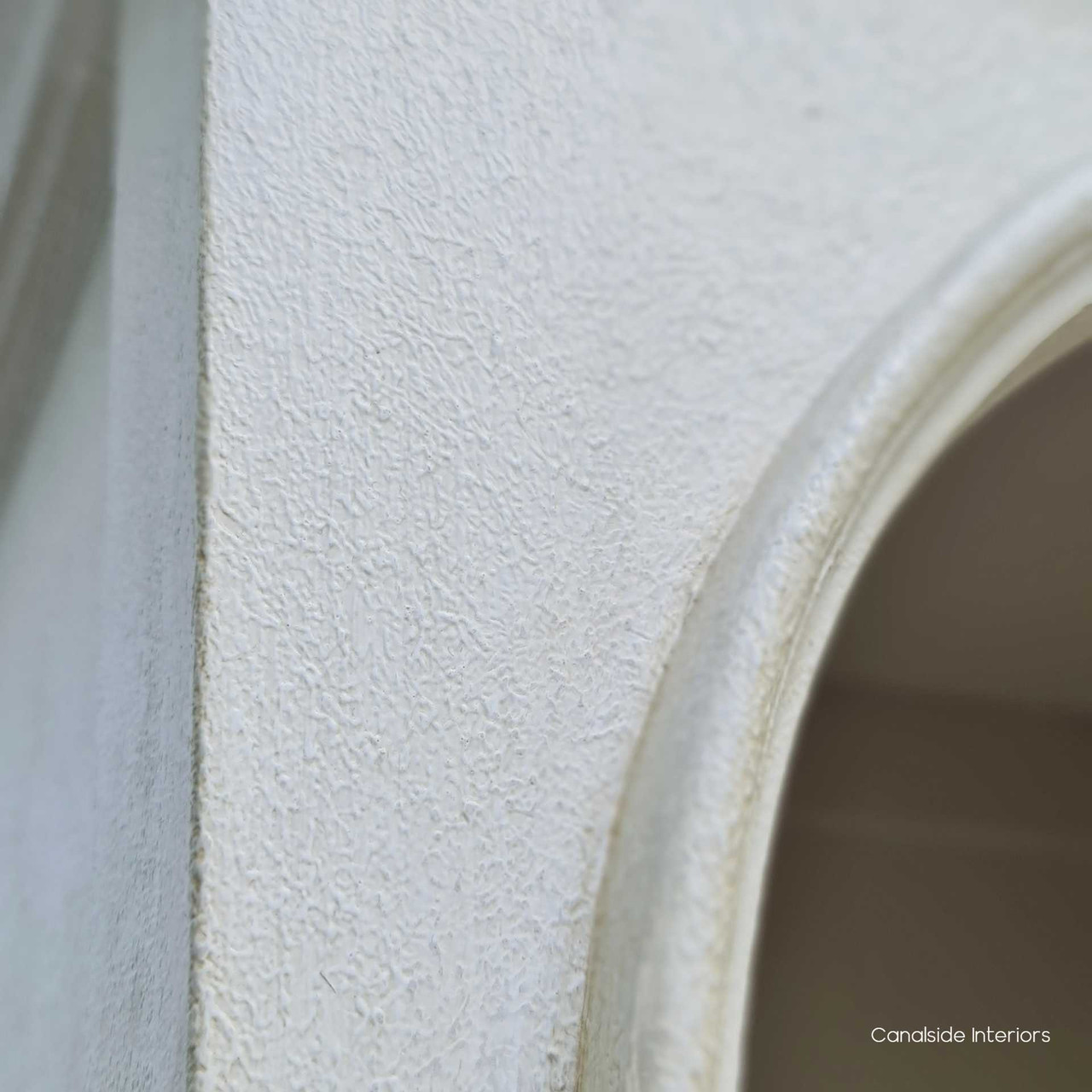 Distressed sesame finish of the Biblioteque Arched Bookshelf captured in natural light, highlighting the texture and age-worn look