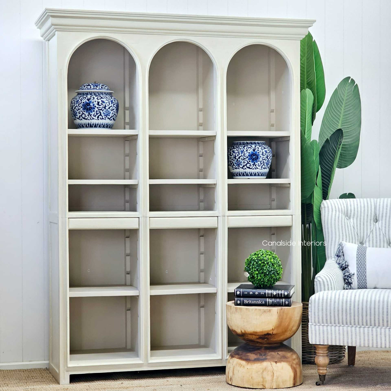 Full view of the Biblioteque Arched Bookshelf against a vibrant backdrop, its eclectic design fitting seamlessly into classical decor