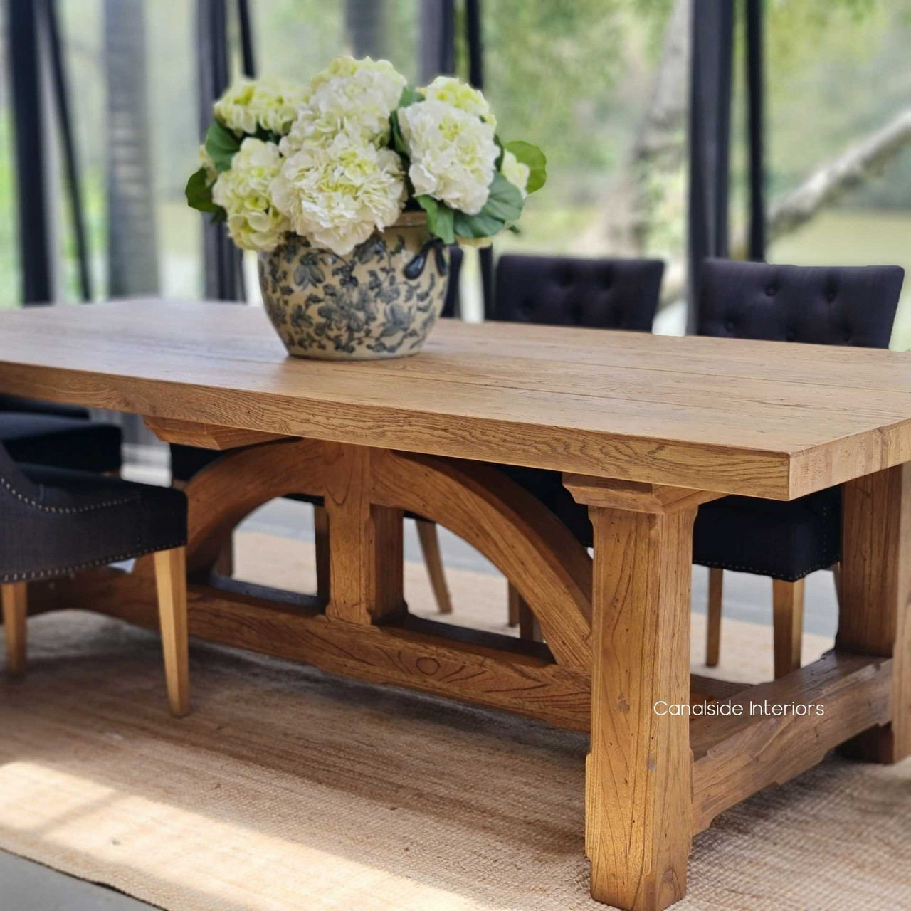 View of the Treadstone Dining Table at Canalside Interiors, showcasing its oak finish and unique base design
