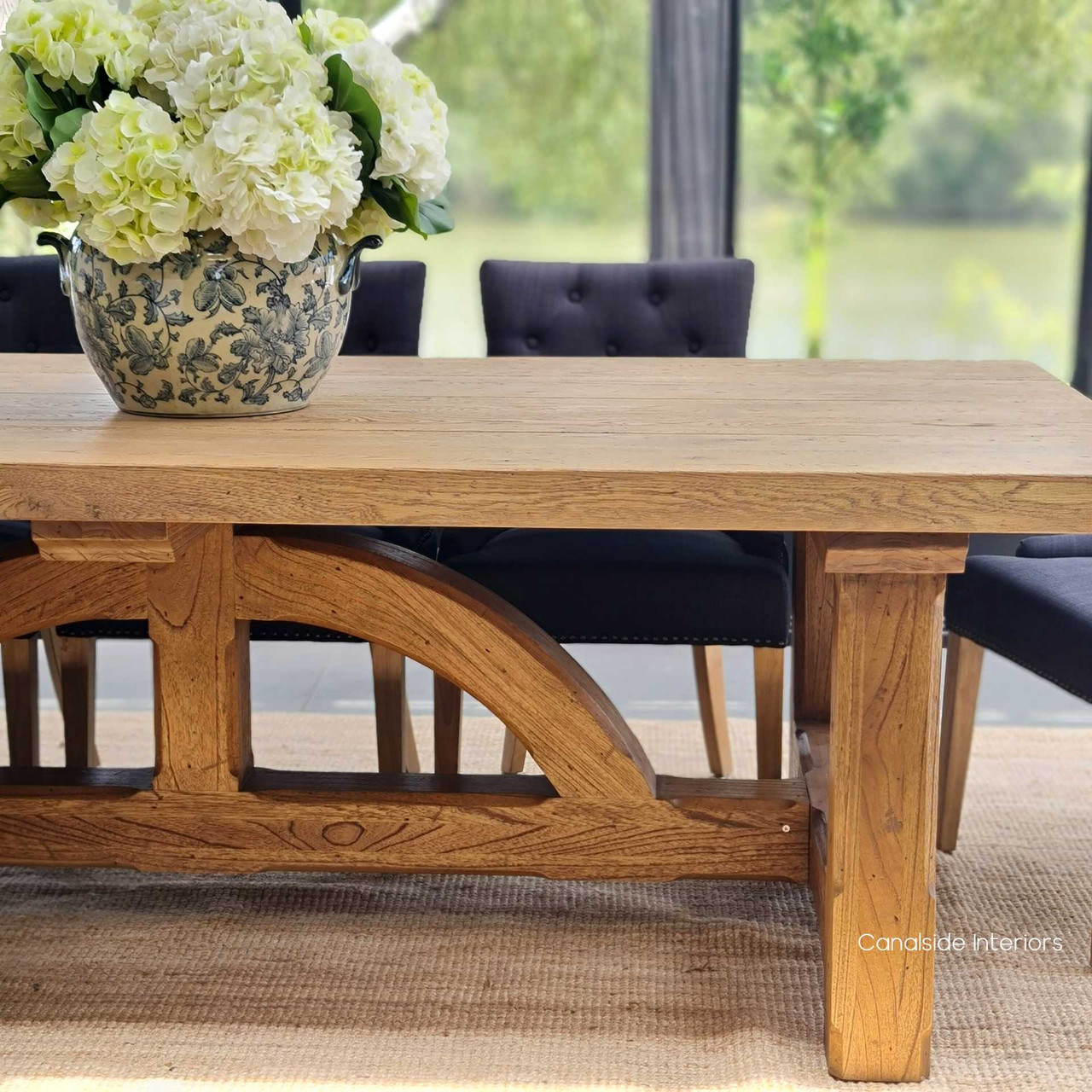 The Treadstone Table as part of an elegant dining room ensemble, enhancing the overall decor with its unique and stylish base.