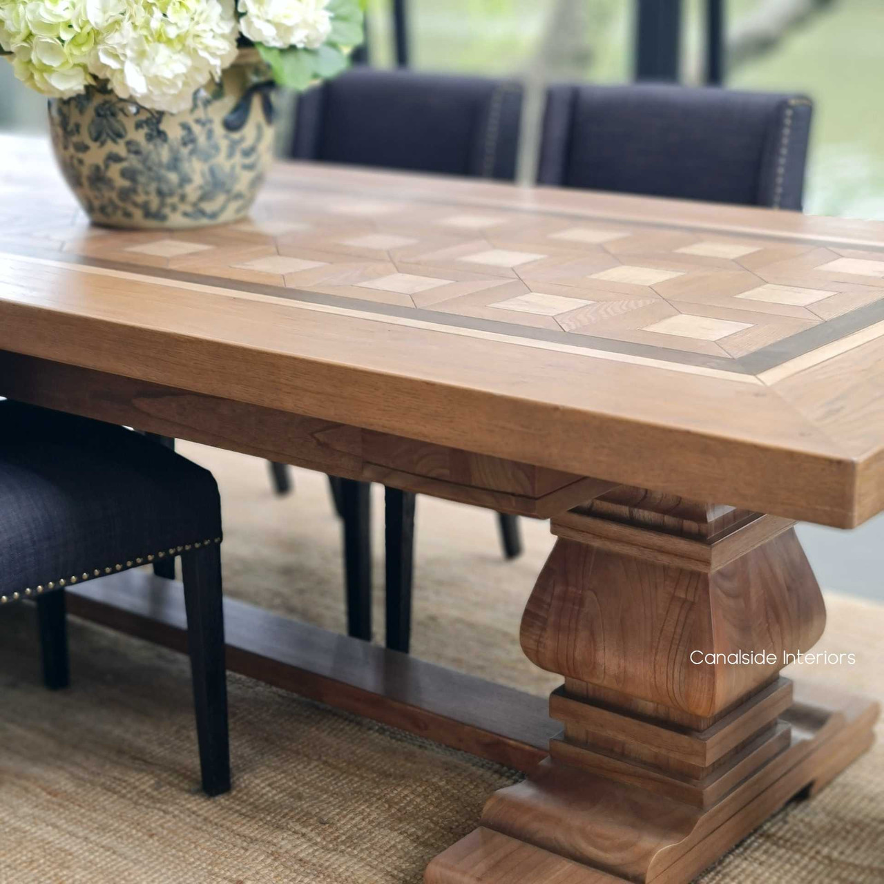 The classic silhouette of the Chambers Dining Table, standing on a detailed pedestal base, infusing timeless quality into a modern dining area.