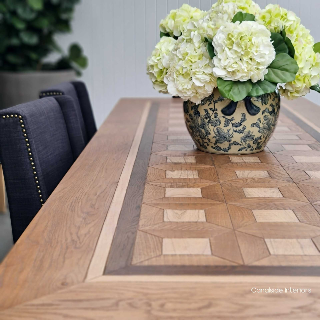 Close-up on the exquisite parquetry inlay of the Chambers Dining Table, showcasing the detailed craftsmanship and timeless design