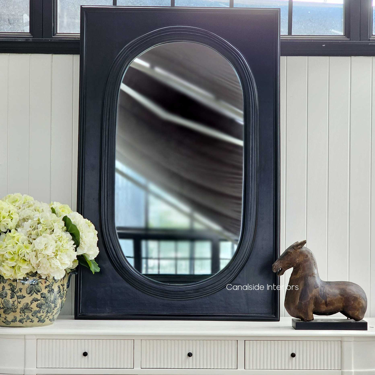 A close view of the Ovalis Mirror's frame, where the distressed black paint reveals layers of character, ideal for a vintage-inspired bedroom