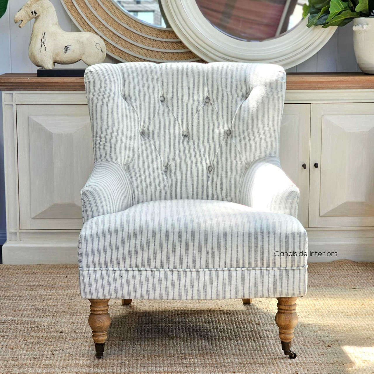 Elegant Ascott Armchair with tufted button detailing, providing a classic touch to a modern coastal living room.