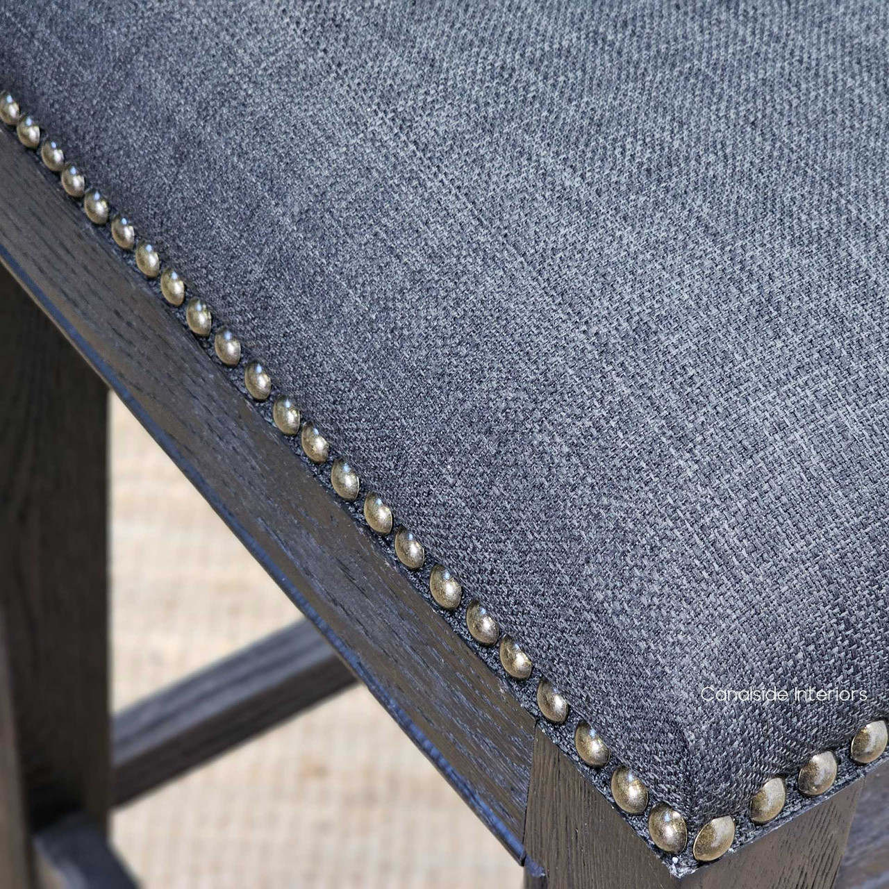 close-up of the Mila II Bar Stool's stud detailing, showcasing the craftsmanship ideal for a coastal-themed living room.