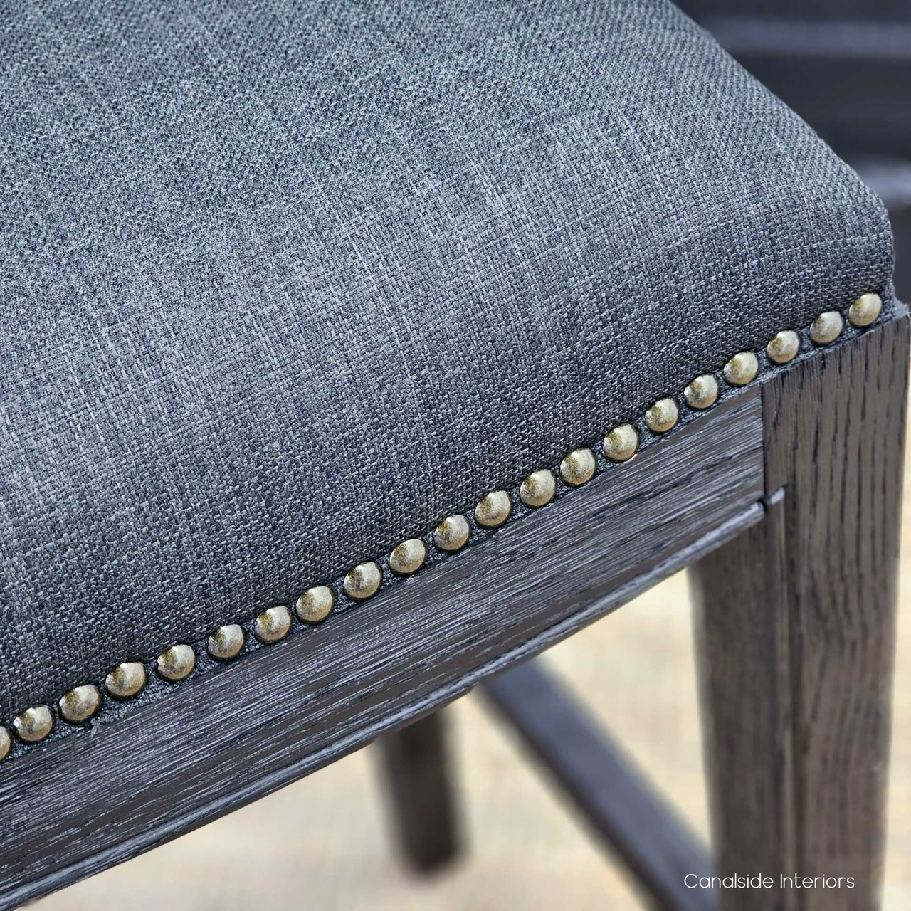 Angled view of the Mila II Bar Stool in black/charcoal, highlighting the espresso oak base suitable for a classical bedroom.