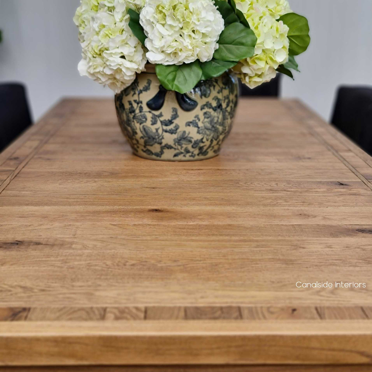 Front view of the Hayworth Dining Table in weathered reclaimed oak, showcasing its minimalist silhouette at Canalside Interiors.