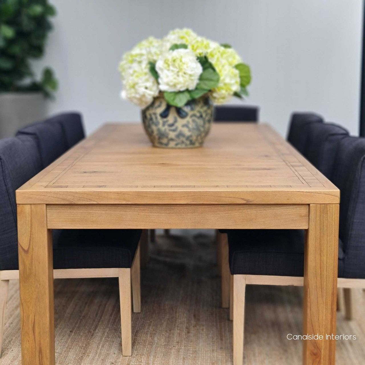 The Hayworth Table as the focal point in a minimalist dining room, showcasing the blend of relaxed luxury and sophisticated design.