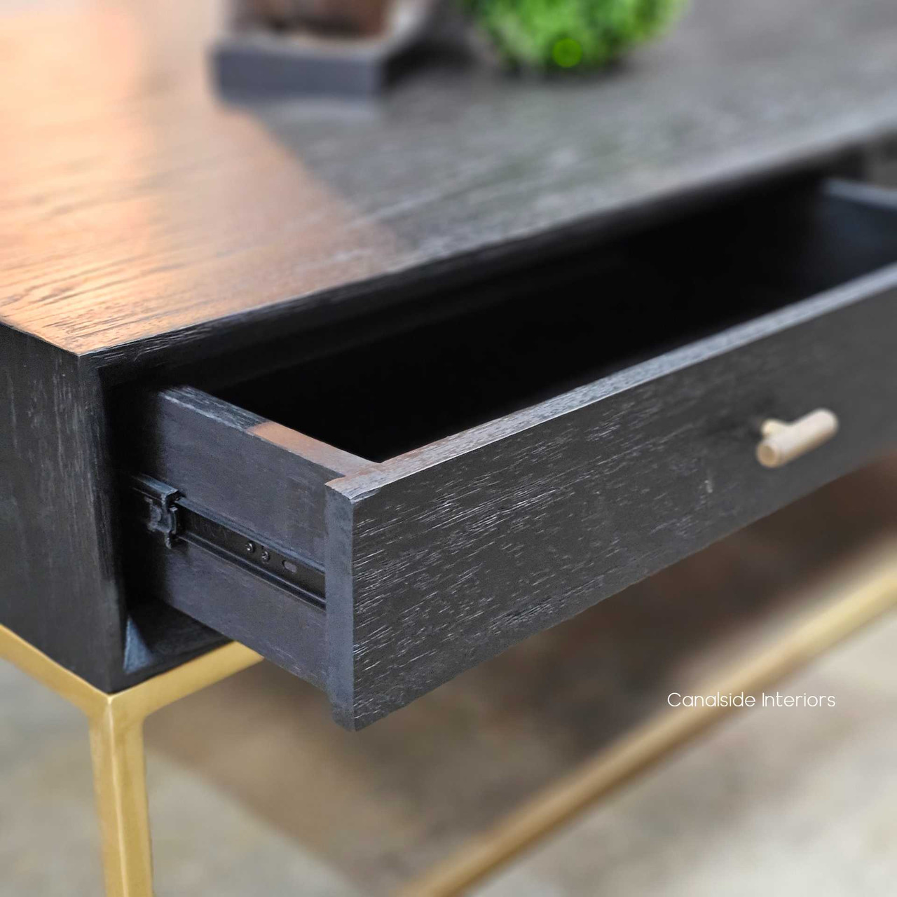 Close up detail of the St Lucia Coffee Table drawer showing metal runners and the gold gilded base