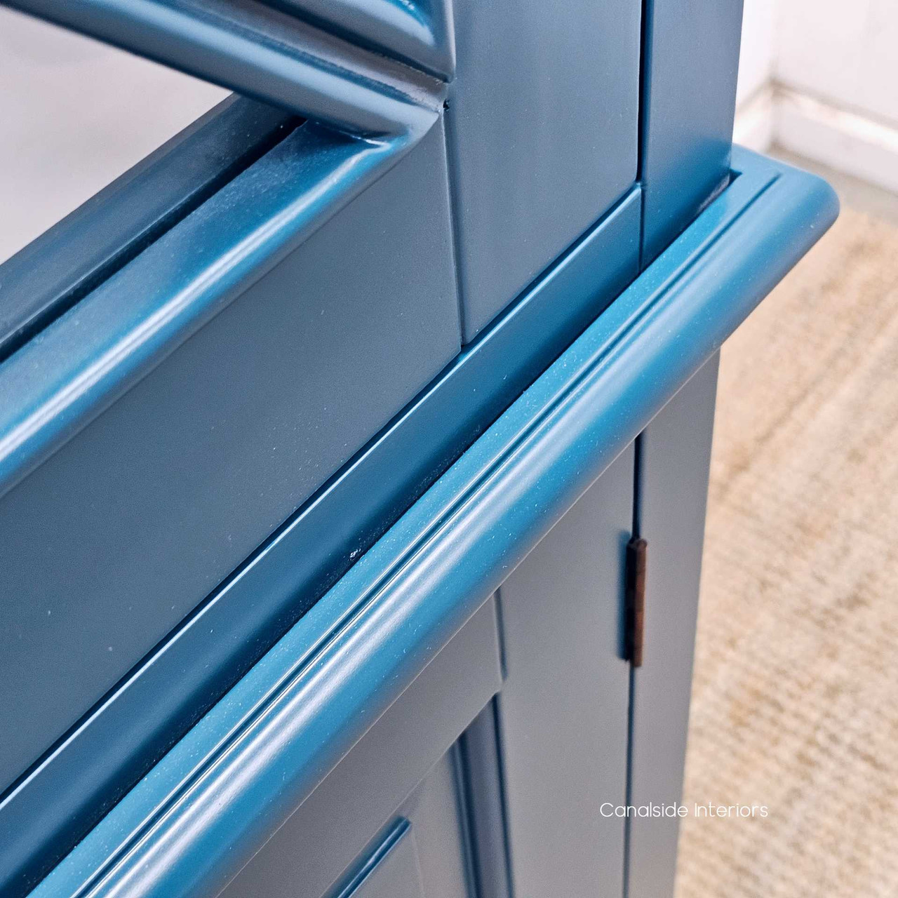 Zoomed-in texture detail of the teal green finish, highlighting the quality wood grain beneath, blending modern aesthetics with natural elements.