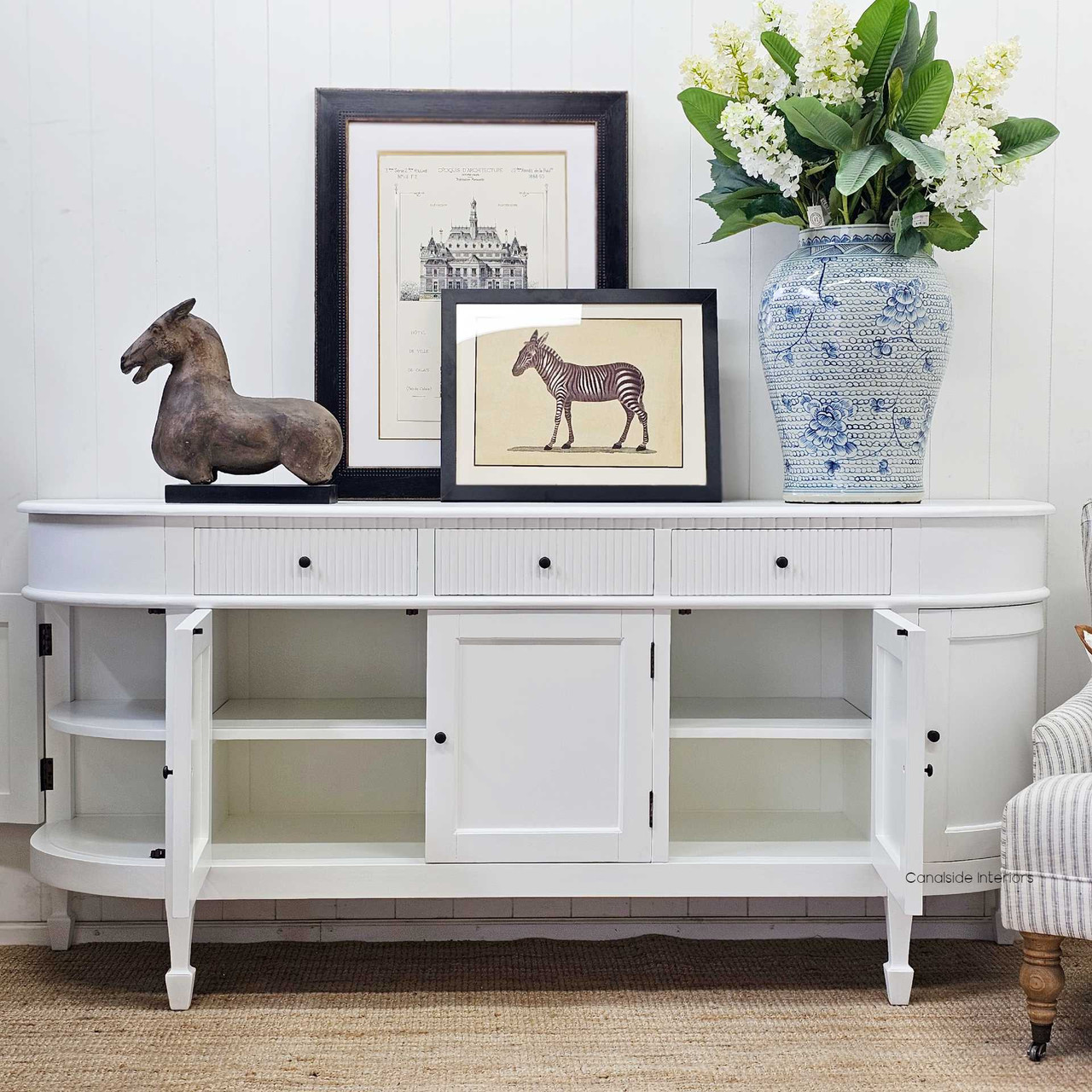 Inside view of an open cabinet in the Louis Curved Buffet, showing shelving options, including curved side door