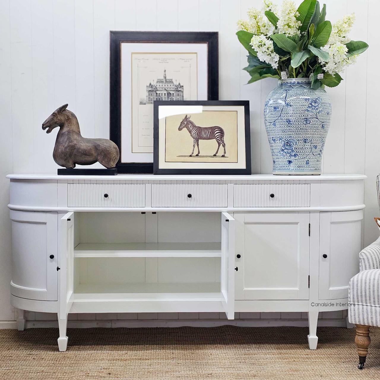 Inside view of an open cabinet in the Louis Curved Buffet, showing shelving options.